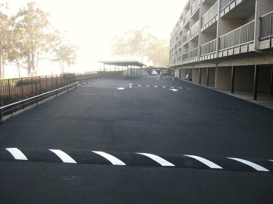 Freshly striped asphalt parking area under a building