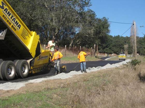 Santana dump truck spreading base rock with the crew