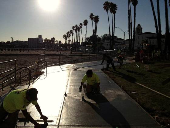 Crew paving a park path at dusk