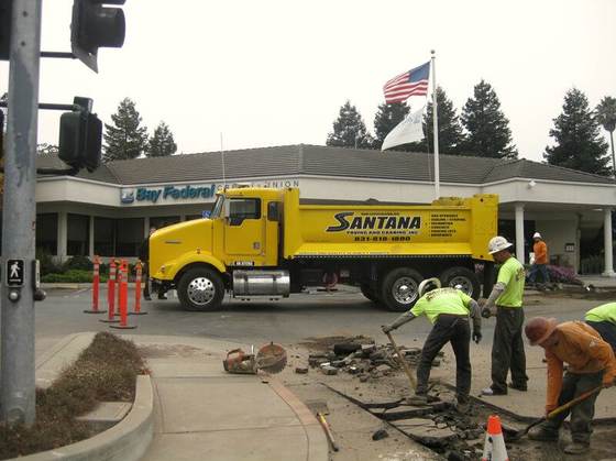 Crew cutting a utility trench at a storefront