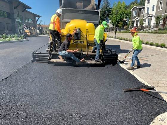 Paving crew laying hot mix behind the paver